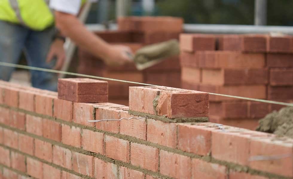 Bricklayer setting a course of face brick